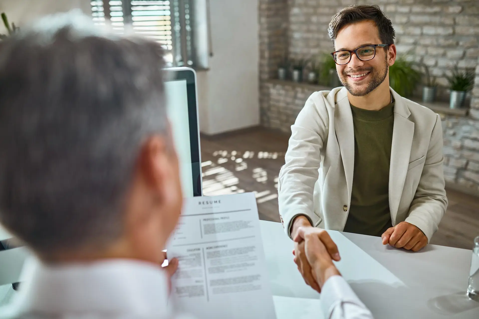 male candidate greeting a member of human resource team on a job interview